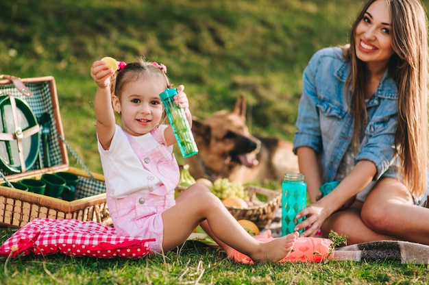 madre e figlia a un picnic con un cane