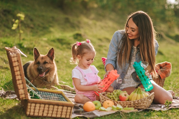 madre e figlia a un picnic con un cane