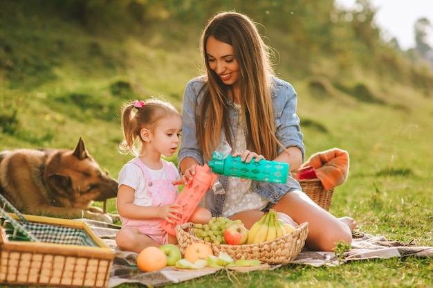 madre e figlia a un picnic con un cane