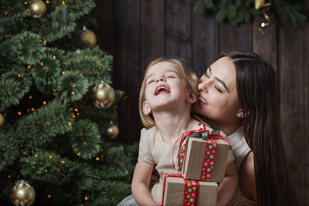 Madre e figlia all'albero di Natale su un legno scuro