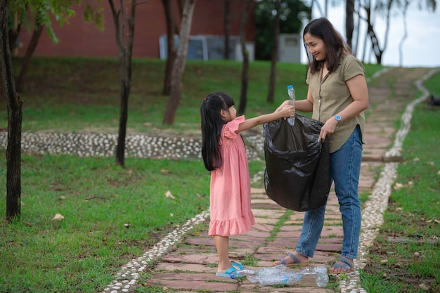 Madre e figlia asiatiche aiutano l'ambiente di beneficenza della raccolta dei rifiuti