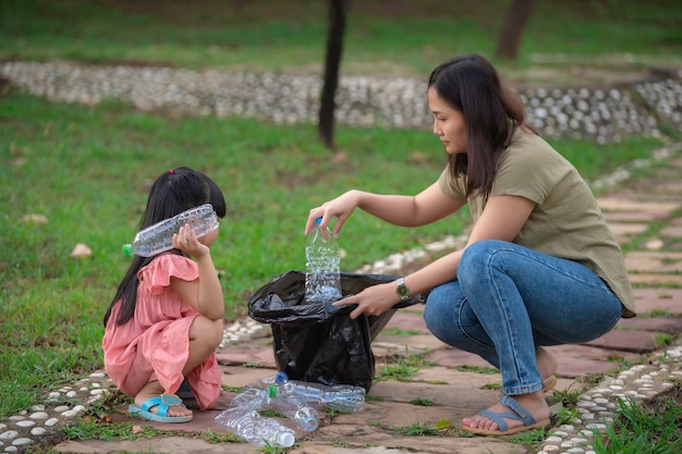 Madre e figlia asiatiche aiutano l'ambiente di beneficenza della raccolta dei rifiuti