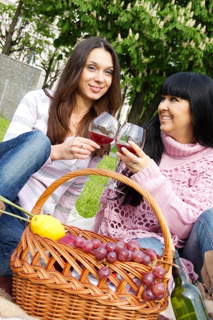 Madre e figlia che bevono vino all'aperto