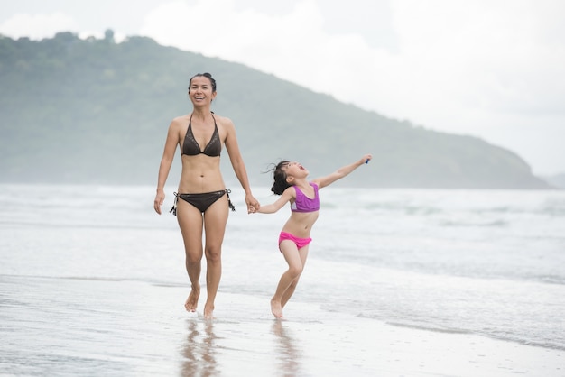 Madre e figlia che camminano sulla spiaggia.