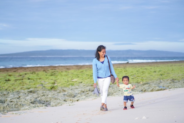 madre e figlia che camminano sulla spiaggia