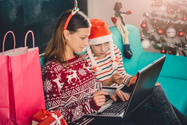 Madre e figlia che comperano online a casa durante il natale