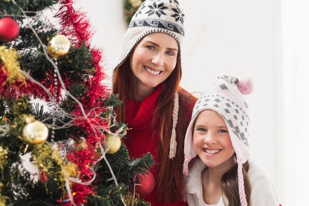 Madre e figlia che decorano l&#39;albero di Natale