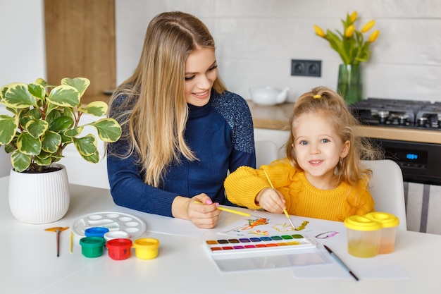 Madre e figlia che dipingono a casa. Kid divertendosi. Educazione della prima infanzia, tempo libero prescolare