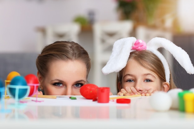 madre e figlia che dipingono le uova di Pasqua a casa