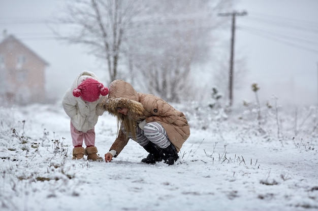 Madre e figlia che esaminano terra nevosa