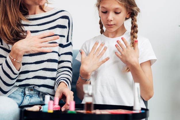 Madre e figlia che fanno manicure a casa dipingono le unghie con lo smalto per unghie