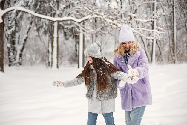 Madre e figlia che giocano a palle di neve in inverno