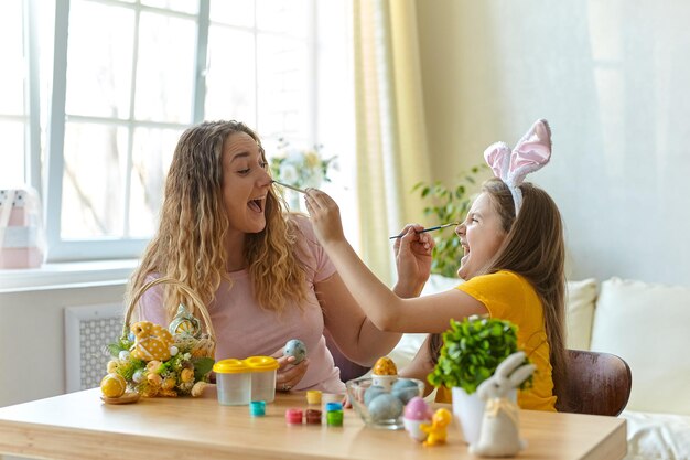 Madre e figlia che giocano con le uova dipinte