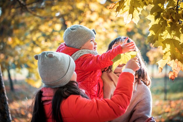 Madre e figlia che giocano insieme durante la passeggiata autunnale