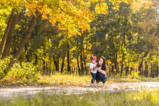 Madre e figlia che giocano insieme nel parco autunnale.