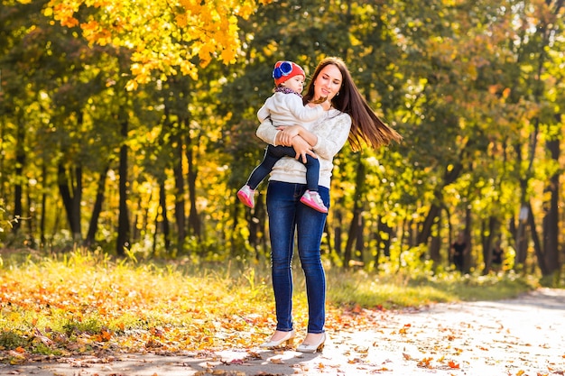 Madre e figlia che giocano insieme nel parco autunnale.