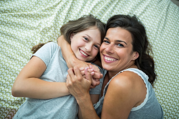 Madre e figlia che giocano sul letto a casa