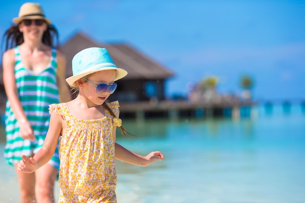 Madre e figlia che godono del tempo alla spiaggia tropicale