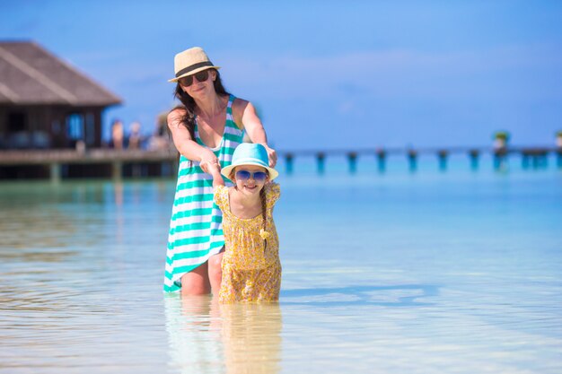 Madre e figlia che godono del tempo alla spiaggia tropicale