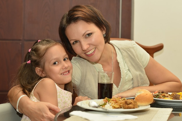 Madre e figlia che mangiano a tavola a casa