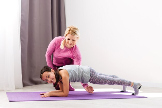 Madre e figlia che praticano yoga a casa