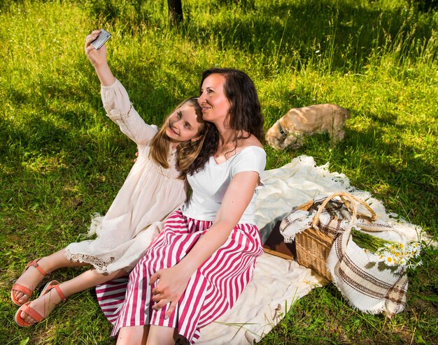 Madre e figlia che prendono un selfie nel parco