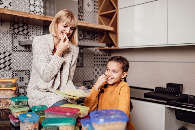 Madre e figlia che preparano insieme le verdure per l'inverno in contenitori sottovuoto. Stanno passando dei bei momenti insieme.