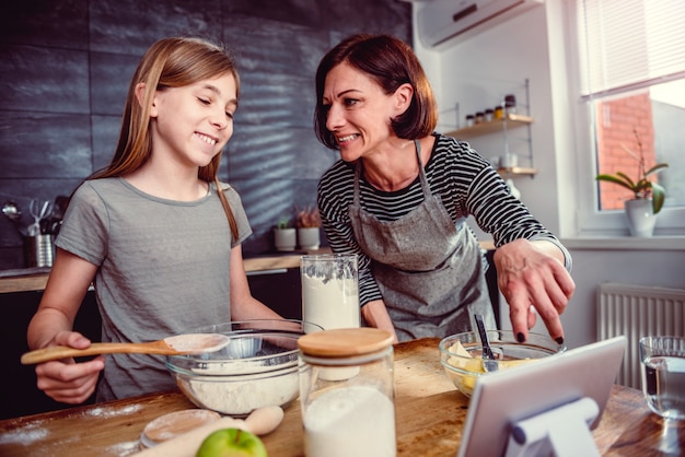 Madre e figlia che producono pasta per la torta di mele