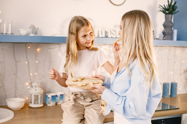 Madre e figlia che provano i biscotti allo zenzero di Natale in cucina