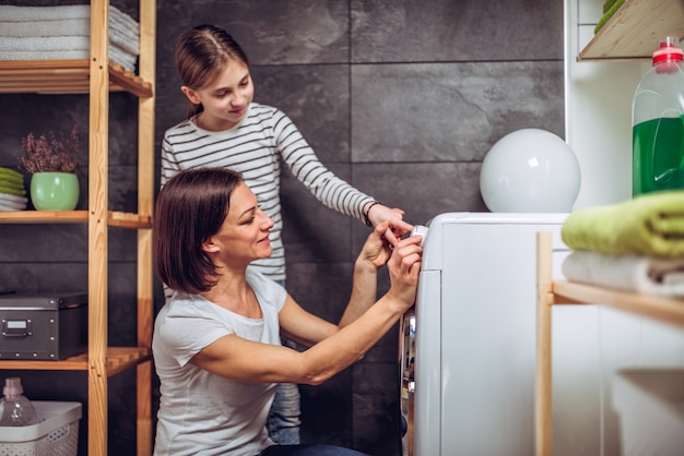 Madre e figlia che selezionano programma sulla lavatrice