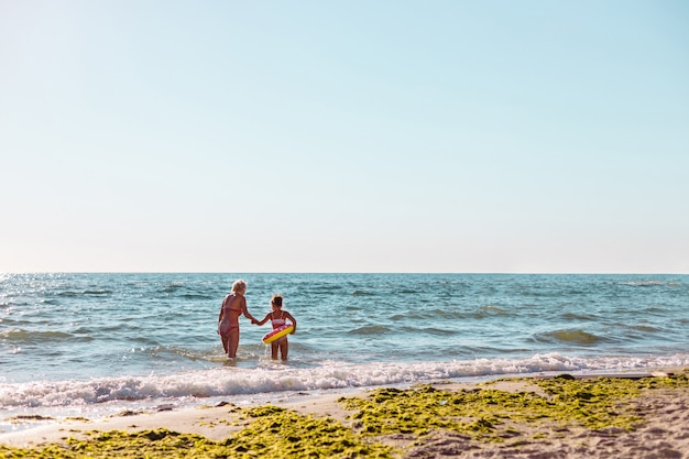 Madre e figlia che si divertono in mare.