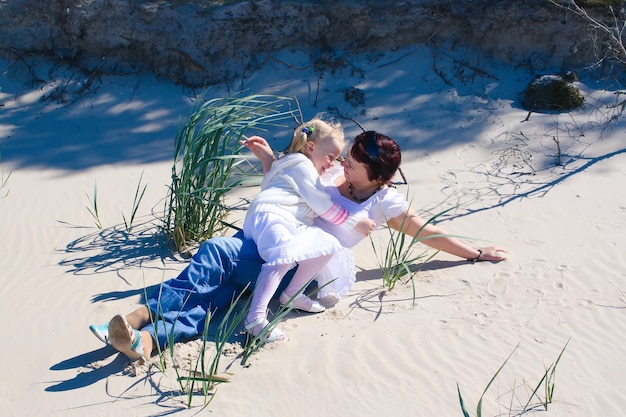 Madre e figlia che si godono il tempo in una calda giornata primaverile sulla costa vicino al Mar Baltico.