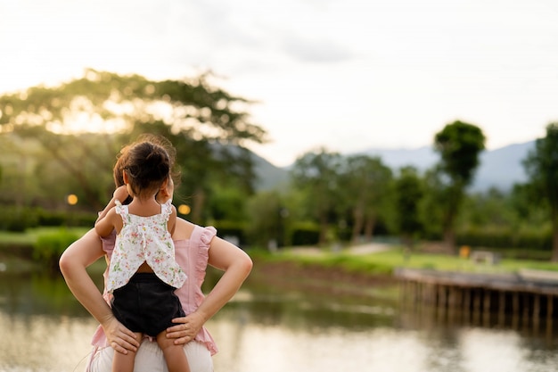 Madre e figlia che si siedono allo stagno