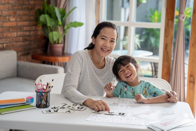 Madre e figlia che sorridono mentre imparando insieme