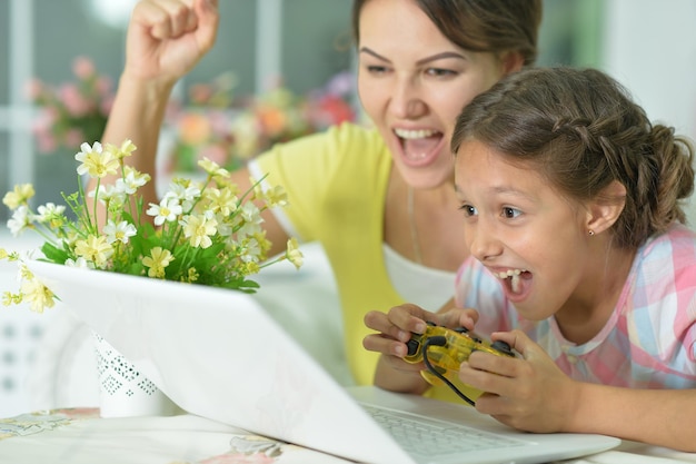 Madre e figlia che usano il computer portatile che giocano