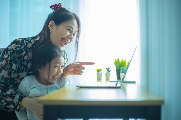 Madre e figlia che usano il laptop mentre effettuano una videochiamata con la connessione del padre