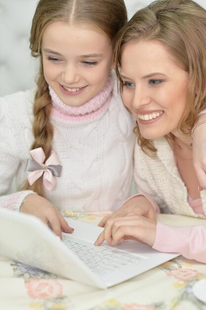 Madre e figlia che utilizzano insieme il computer portatile a casa