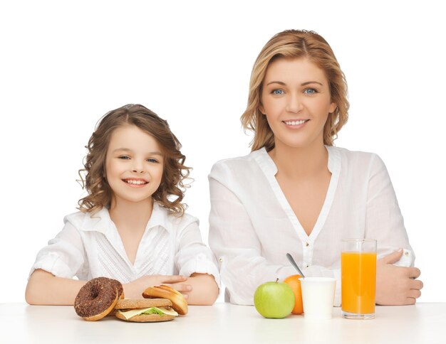 madre e figlia con cibo sano e malsano