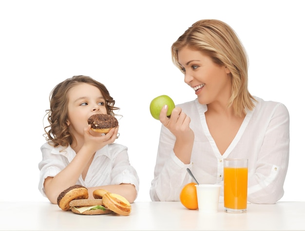 madre e figlia con cibo sano e malsano