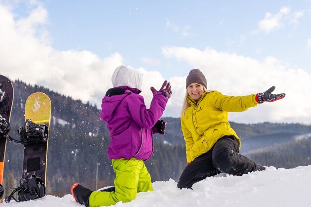 madre e figlia con lo snowboard al resort invernale