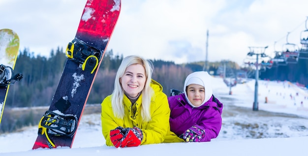 madre e figlia con lo snowboard in una località di montagna