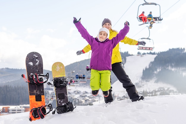 madre e figlia con lo snowboard in una località di montagna