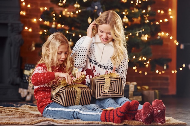 Madre e figlia con regali che celebrano insieme le vacanze di natale.