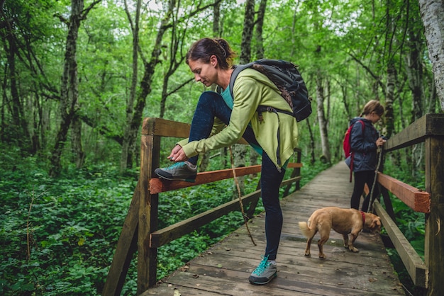 Madre e figlia con un cane che fa un'escursione nella foresta