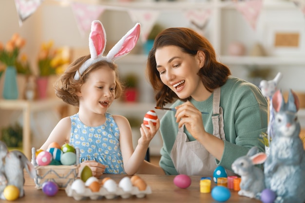 Madre e figlia dipingono le uova Famiglia felice che si prepara per la Pasqua