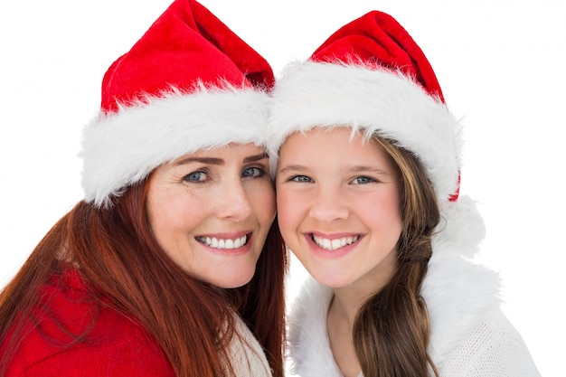 Madre e figlia festive che sorridono alla macchina fotografica