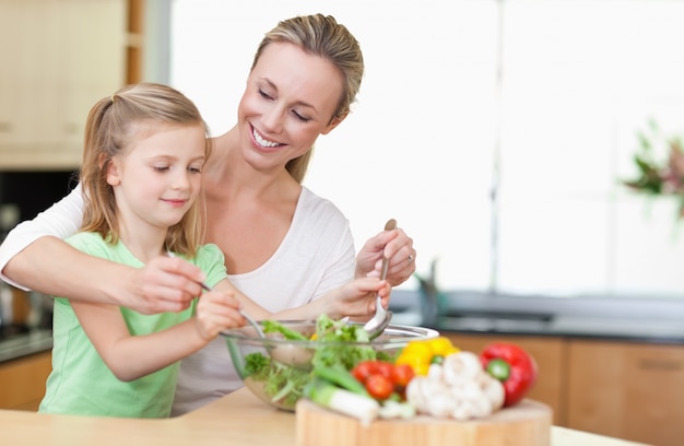 Madre e figlia mescolando insalata