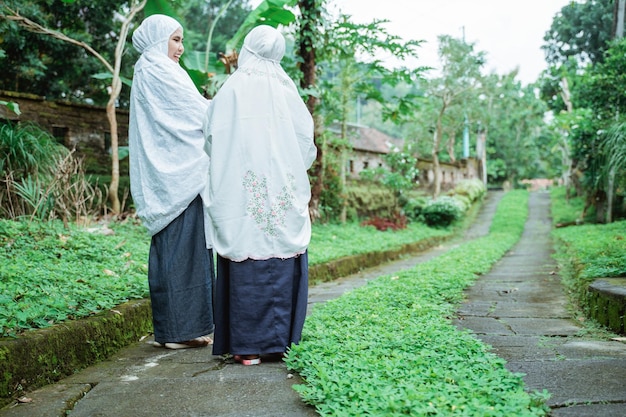 Madre e figlia musulmane che vanno alla moschea mentre indossano l'hijab