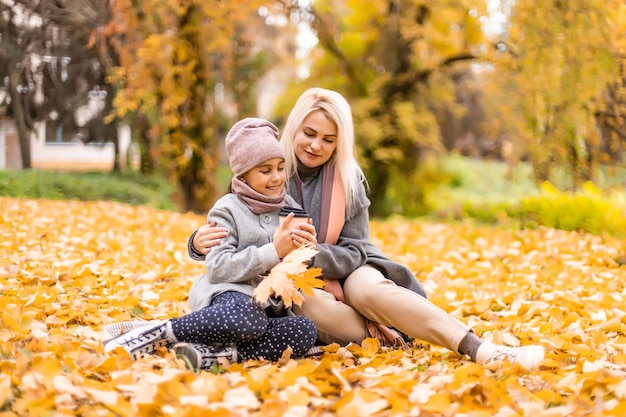 Madre e figlia nel parco giallo autunnale.