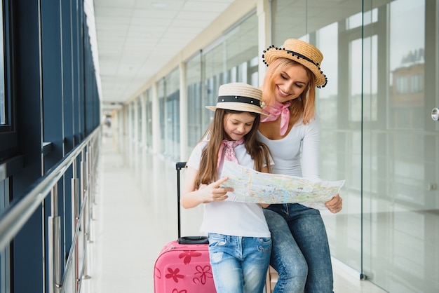 Madre e figlia piccola con i bagagli in aeroporto